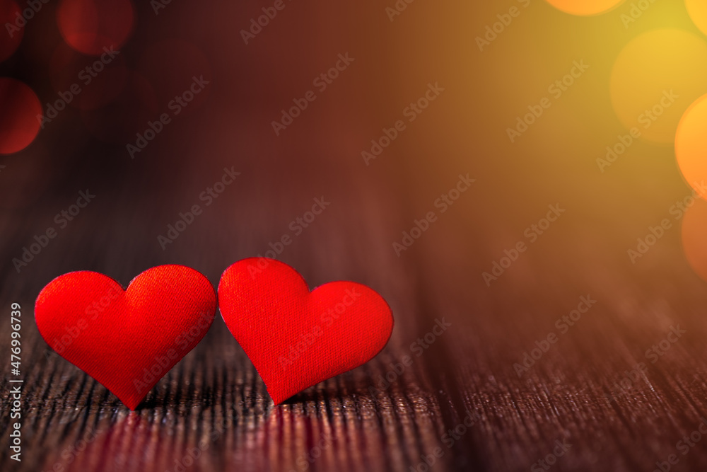 Fototapeta premium Valentine's Day background with two red hearts on a beautiful background with multicolored bokeh. Love concept. Festive background.