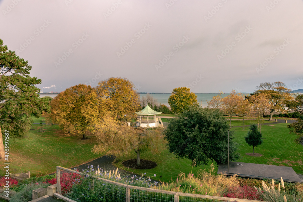 Fototapeta premium Blackrock, Dublin, Ireland, November 12, 2021:A view of Dublin Bay from Blackrock looking across Blackrock Part which features a Bands stand and landscaped gardens that lead to the coast line