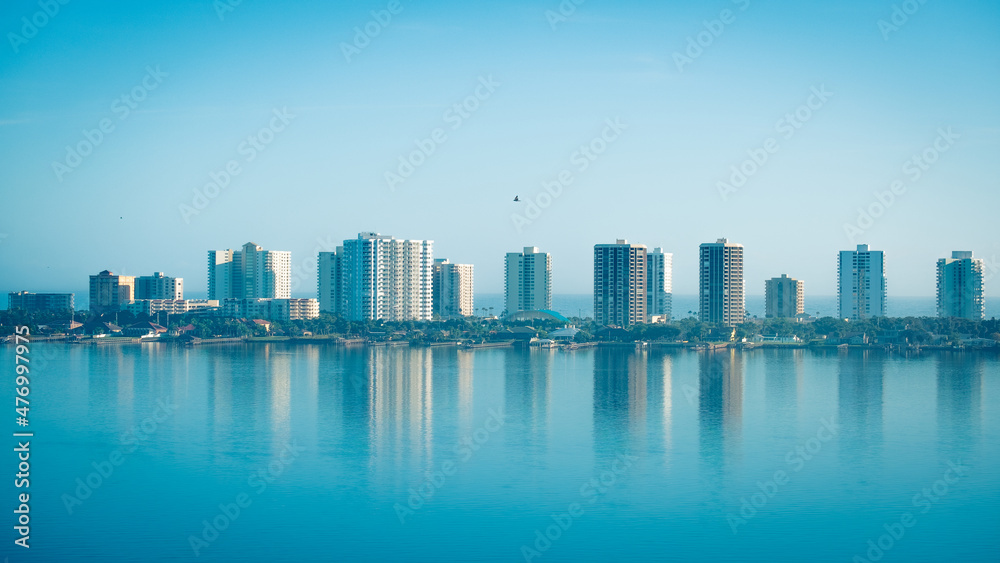 Highrise buildings along Halifax river at Daytona Beach in Florda with seabird soaring over water