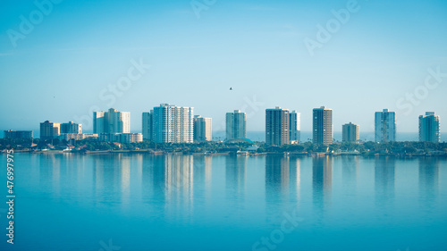 Highrise buildings along Halifax river at Daytona Beach in Florda with seabird soaring over water photo
