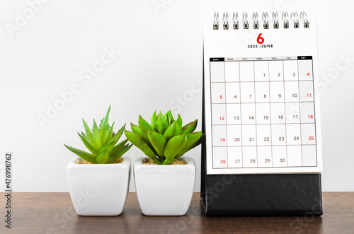 June 2022 desk calendar on wooden table.