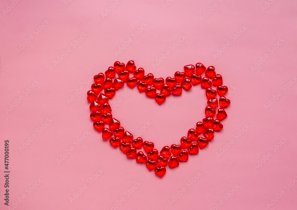 Valentine's day concept. Heart of beads in the shape of a heart of red on a pink background. Copy space. Love symbol.