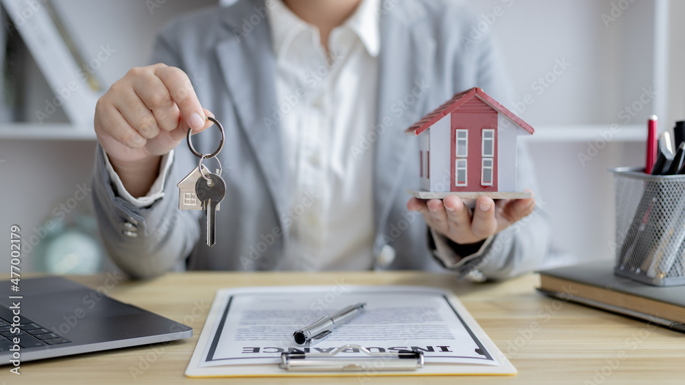 Fototapeta premium Sales manager or salesperson holds a demo house and has a home purchase contract with keys to deliver to customer buys a house, Sales Service, Home salesman with insurance.