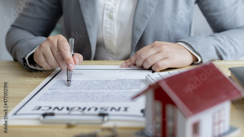 Selling a house with insurance, Sales managers or dealers have signed approval to open a housing project with a model house, Home-Real Estate and Insurance concept.