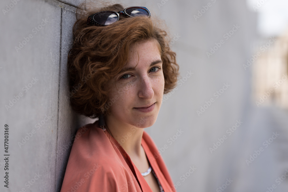 Fototapeta premium young woman standing against a wall
