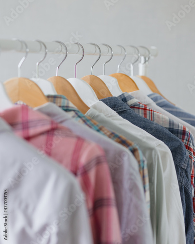 dressing room or rail with clothes on hangers shirts and dresses. a clothing store or boutique. a female stylist picks up a wardrobe or collects things for recycling. eco-friendly life and clothing