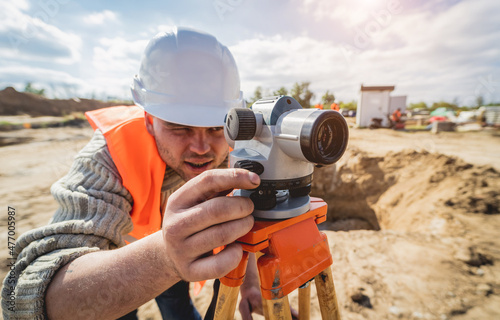 Surveyor worker with theodolite equipment at construction site photo