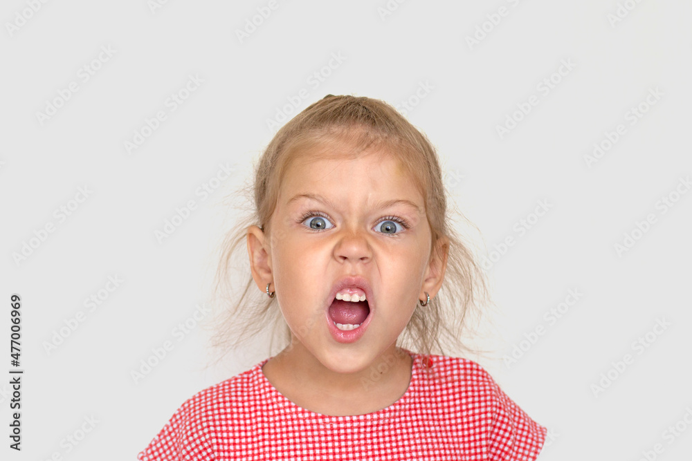 Portrait of funny caucasian little girl of 5 years looking at camera with open mouth and angry face like animal on white background