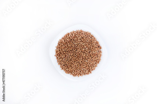 Buckwheat. Buckwheat in a white plate on white background, top view. Healthy food. Cereals