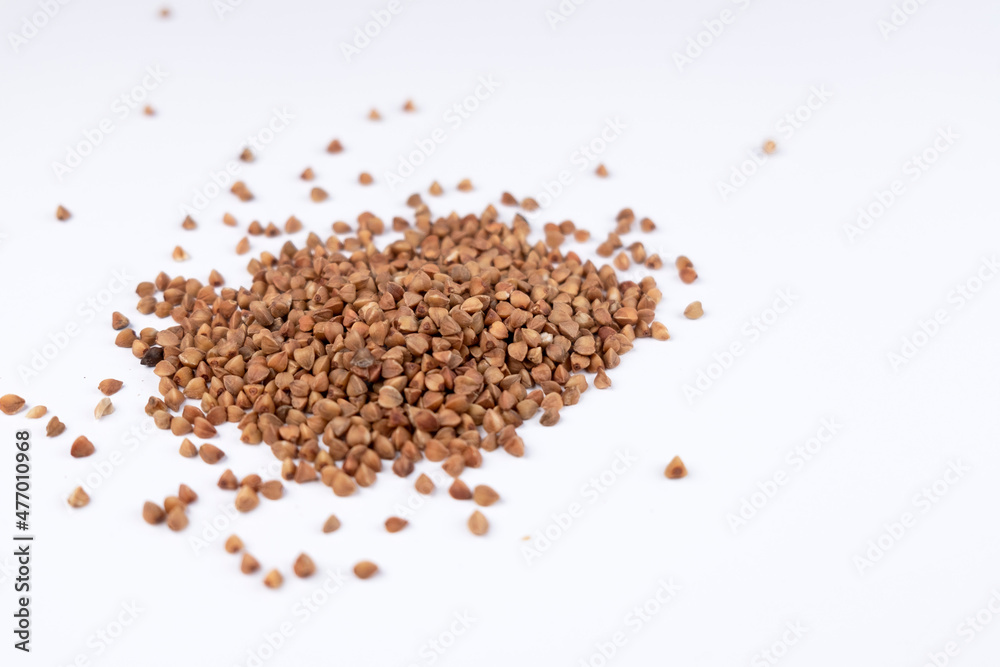 Pile of buckwheat on white background. Buckwheat seeds isolated on white background Pile of buckwheat on white background. Buckwheat seeds isolated on white background