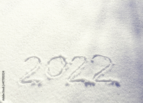 The inscription on the snow New 2022. Christmas Eve, winter day with snowfall. flying snowflakes. there are shiny winter snowdrifts on the ground, New Year's mood outside