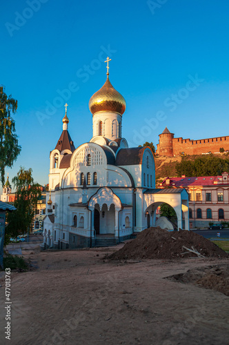 Church of the Kazan Icon of the Mother of God. Temple, view from the mountain against the background of the Nizhny Novgorod Kremlin with a blue sky, Sunset rays of the sun on the domes. 