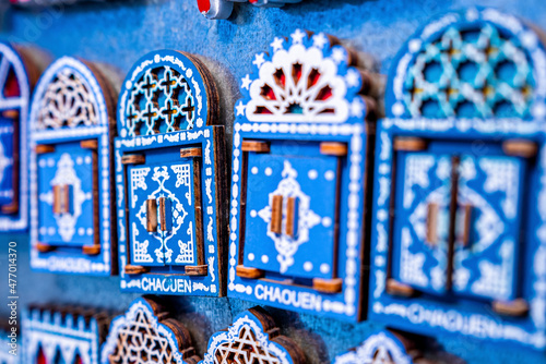 Chefchaouen, Morocco. October 10, 2021. Variety of small wooden door shaped design magnets for sale at local bazaar © Aerial Film Studio