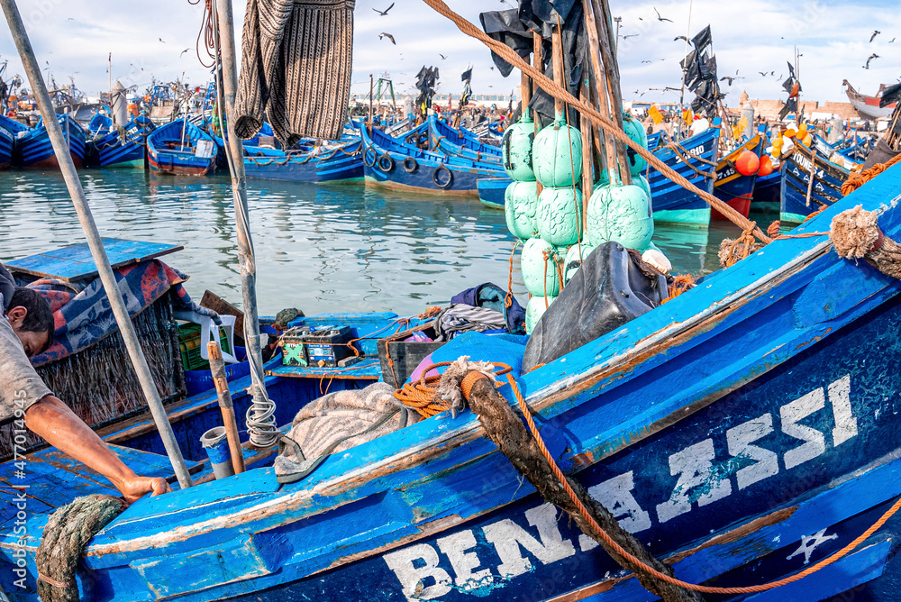 Essaouira, Morocco. October 10, 2021. Small fishing boats moored on coast at port against cloudy sky, Wooden fishing boats moored in harbor Essaouira, Morocco. October 10, 2021. Small fishing boats moored on coast at port against cloudy sky, Wooden fishing boats moored in harbor