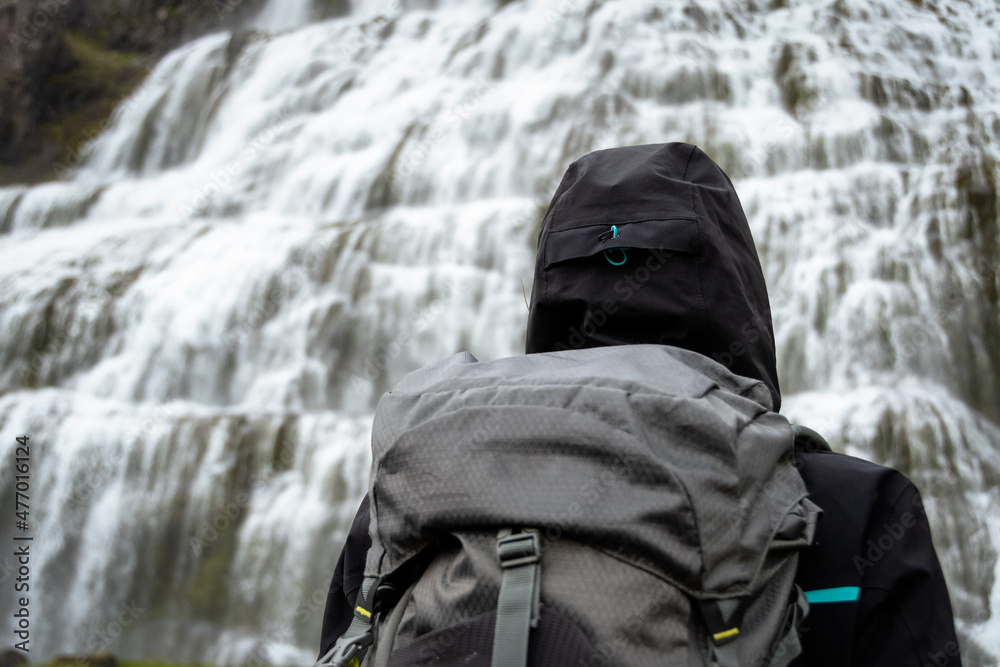 Backpacker enjoying the view of majestic Dynjandi waterfall, largest waterfall in Westfjords - Iceland Backpacker enjoying the view of majestic Dynjandi waterfall, largest waterfall in Westfjords - Iceland