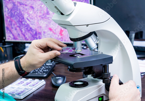 Laboratory assistant works with microscope at the modern laboratory. photo