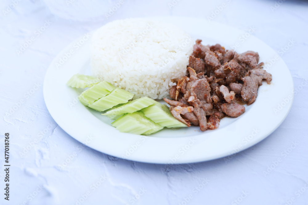 Pork with garlic with rice and cucumber, favorite menu in Thailand resturant.