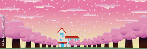 春の桜並木の奥に見える校舎・園舎 