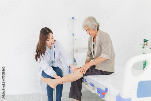 asian female doctor holding leg of old stroke patient in hospital, elderly rehabilitation clinic, they training to rehab muscle, Knee Replacement, Osteoarthritis of the Knee