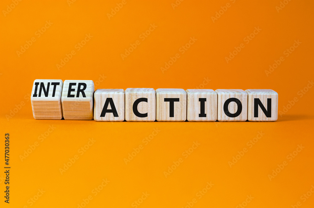 Action or interaction symbol. Turned wooden cubes and changed the word action to interaction. Beautiful orange background, copy space. Business and action or interaction concept. Action or interaction symbol. Turned wooden cubes and changed the word action to interaction. Beautiful orange background, copy space. Business and action or interaction concept.