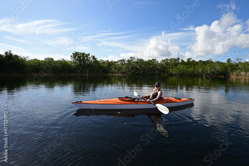 Young woman kayaking on tranquil waters of Nine Mile Pond in Everglades National Park, Florida on sunny afternoon.