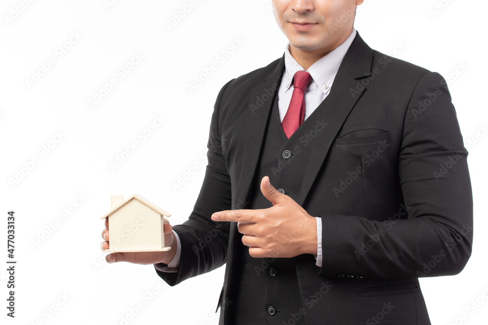Businessman in gray suit holding model house and money, save money for future, repair home and retirement isolated on white background. Business loans for real estate concept. Businessman in gray suit holding model house and money, save money for future, repair home and retirement isolated on white background. Business loans for real estate concept.