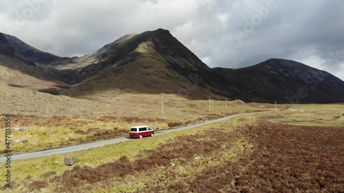 A panning aerial shot in the wilderness with a VW campervan, in the far outreaches of the Scottish Highlands towards the Isle of Skye in Scotland.  photo