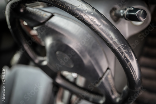 Threadbare automotive black leather steering wheel of old auto close-up © GMisman