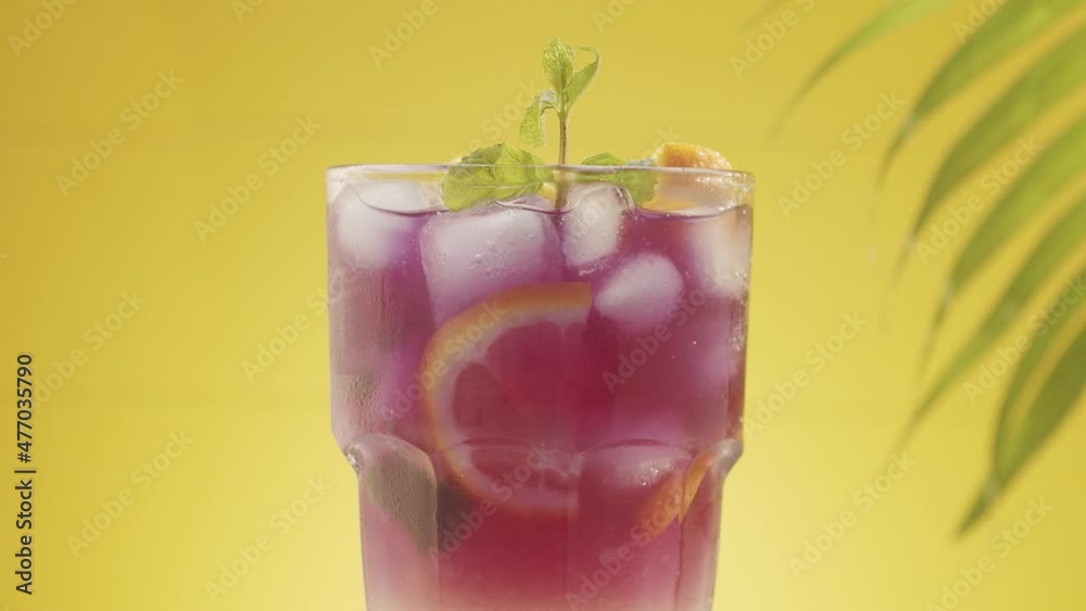 Pieces of ice and lime fall into a glass of refreshing summer lemonade cocktail Pieces of ice and lime fall into a glass of refreshing summer lemonade cocktail