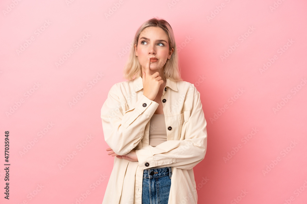 Young caucasian woman isolated on pink background having doubts while looking up Young caucasian woman isolated on pink background having doubts while looking up