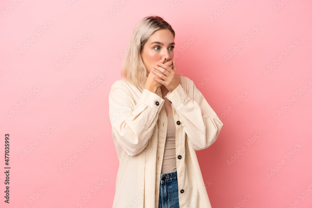 Young caucasian woman isolated on pink background covering mouth and looking to the side Young caucasian woman isolated on pink background covering mouth and looking to the side