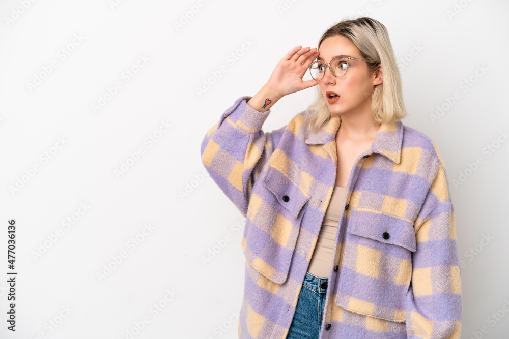 Young caucasian woman isolated on white background with surprise expression while looking side