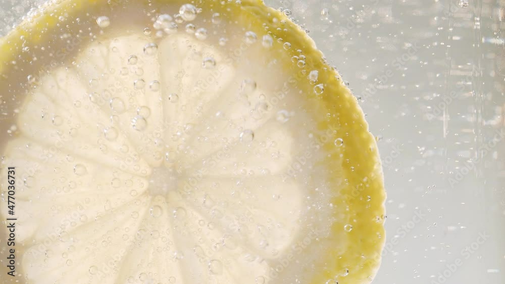 Slice of lemon with bubbles Macro close-up for refreshing cold cocktail lemonade