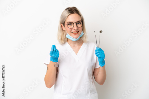 Dentist caucasian woman holding tools isolated on white background making money gesture