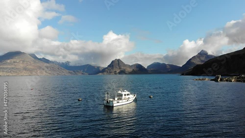 Rare aerial footage capturing a cinematic shot of the Cullin Mountain range in full from the south of The Isle of Skye on a small headland town called Elgol. photo