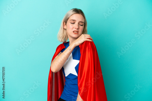 Super Hero caucasian woman isolated on blue background suffering from pain in shoulder for having made an effort