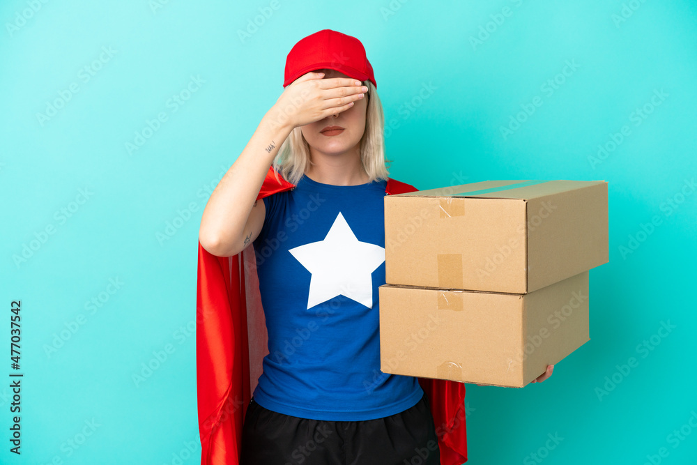 Super Hero caucasian delivery woman isolated on blue background covering eyes by hands. Do not want to see something Super Hero caucasian delivery woman isolated on blue background covering eyes by hands. Do not want to see something
