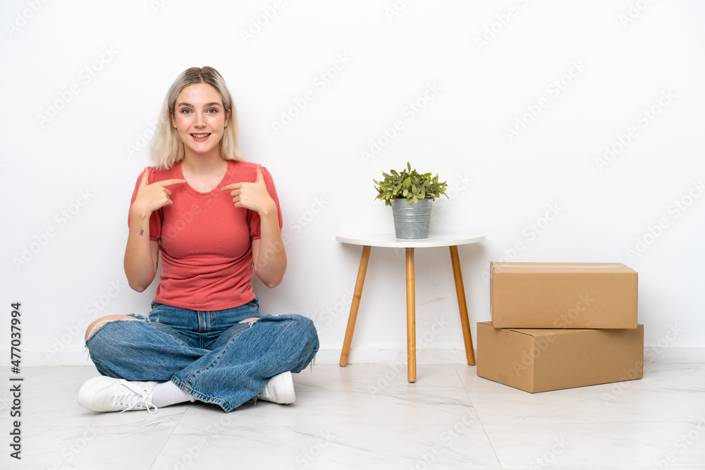 Young woman moving in new home among boxes isolated on white background with surprise facial expression Young woman moving in new home among boxes isolated on white background with surprise facial expression
