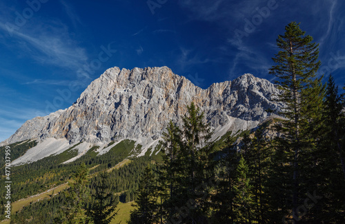 Alpiner Bergblick im Morgenlicht an einem sonnigen Sommertag auf der Ehrwalder Alm mit Blick auf die Zugespitze und anderen Berge an der Südseite des Wettersteingebirges in Tirol, Österreich