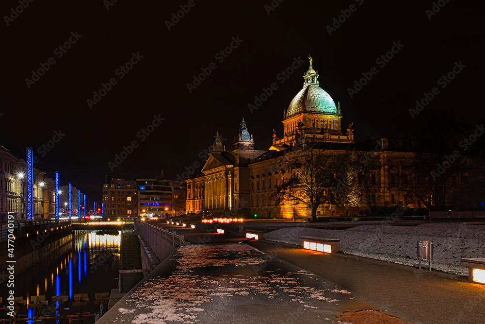 Fototapeta premium Beleuchtetes Bundesverwaltungsgericht bei Nacht mit Pleißemühlgraben, historisches Justizgebäude und moderne Stadtbeleuchtung, Leipzig, Sachsen, Deutschland