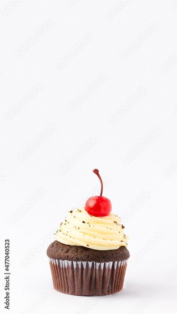 Muffin with topping and a cherry on top, isolated over a white background. Vertical banner with copy space. Muffin with topping and a cherry on top, isolated over a white background. Vertical banner with copy space.