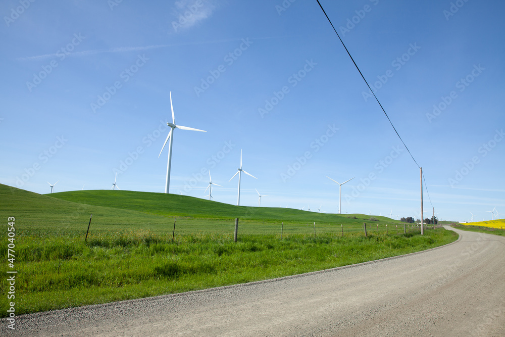 Wind turbine with blue sky and country road 