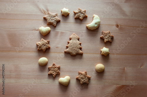 Christmas cookies - star figures, heart figures, moon figure and Christmas tree is in the center. Different figures of ginger biscuits on a wood table