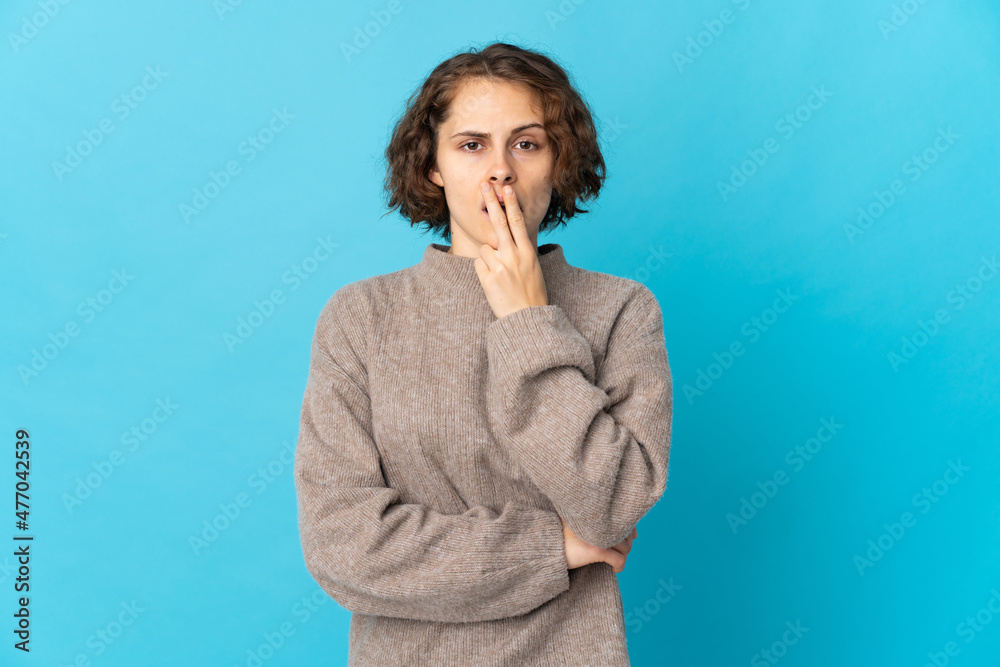 Young English woman isolated on blue background surprised and shocked while looking right Young English woman isolated on blue background surprised and shocked while looking right
