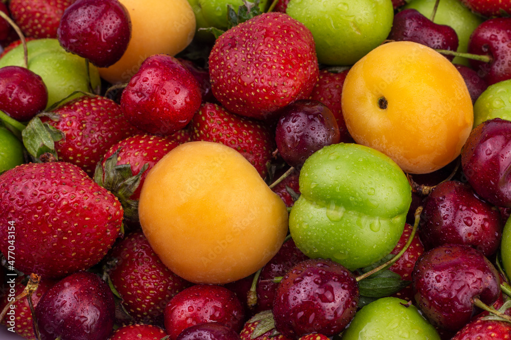 Ripe strawberry, apricot, cherry, green plum with water drops. Fresh Summer fruit background close up image. Ripe strawberry, apricot, cherry, green plum with water drops. Fresh Summer fruit background close up image.