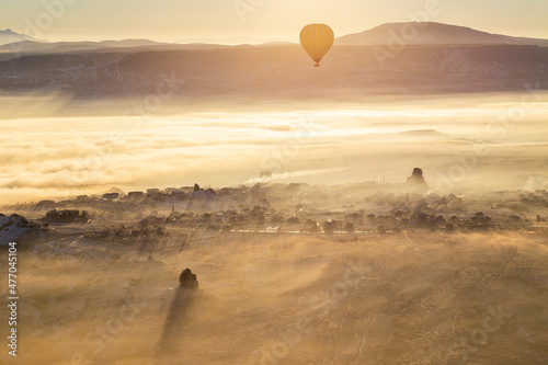 Hot air balloons flying over spectacular Cappadocia. Beautiful view of hot air balloons floating in sunrise blue sky over the mountain landscape of fairy chimneys