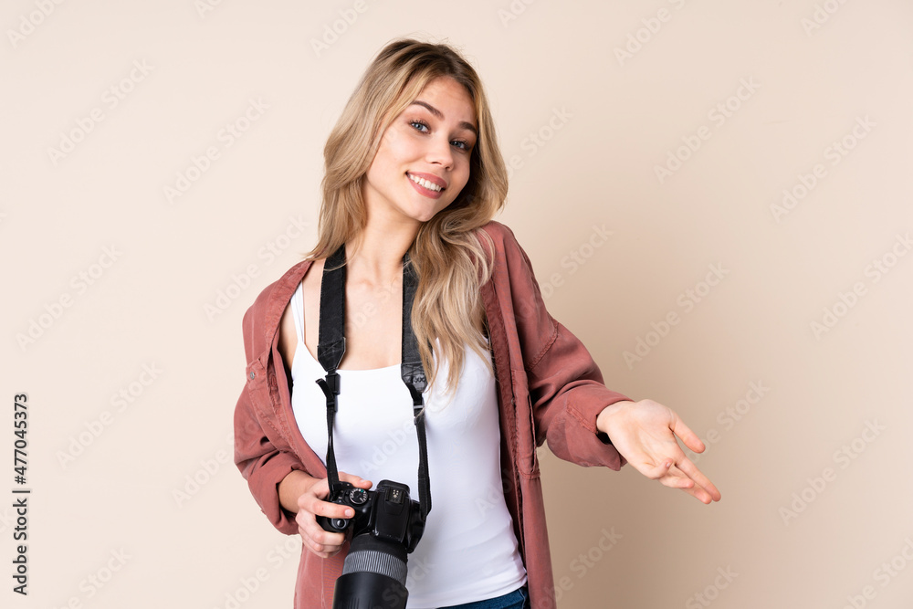 Young photographer girl over isolated background smiling Young photographer girl over isolated background smiling