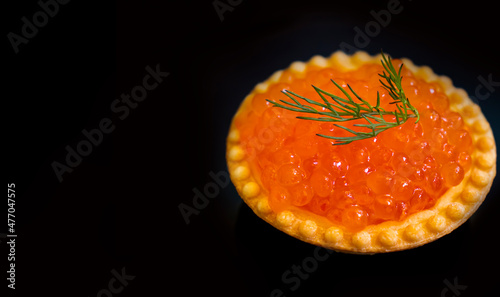 red caviar in a tartlet on a black background