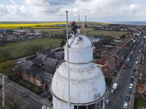 Ian Hairsine painting the top of the 127 ft high Withernsea Lighthouse, East Yorkshire, UK photo