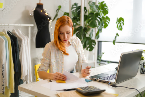 Young entrepreneur woman working in her fashion design studio photo